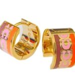 coach signature enamel huggie earrings featuring an animal print pattern and gold tone finish.