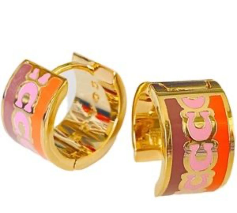 coach signature enamel huggie earrings featuring an animal print pattern and gold tone finish.