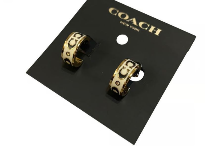 coach signature enamel huggie earrings in gold and white