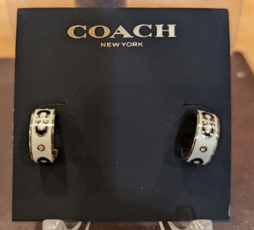 coach signature enamel huggie earrings in gold and white