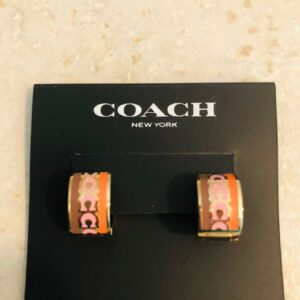 coach signature enamel huggie earrings featuring an animal print pattern and gold tone finish.