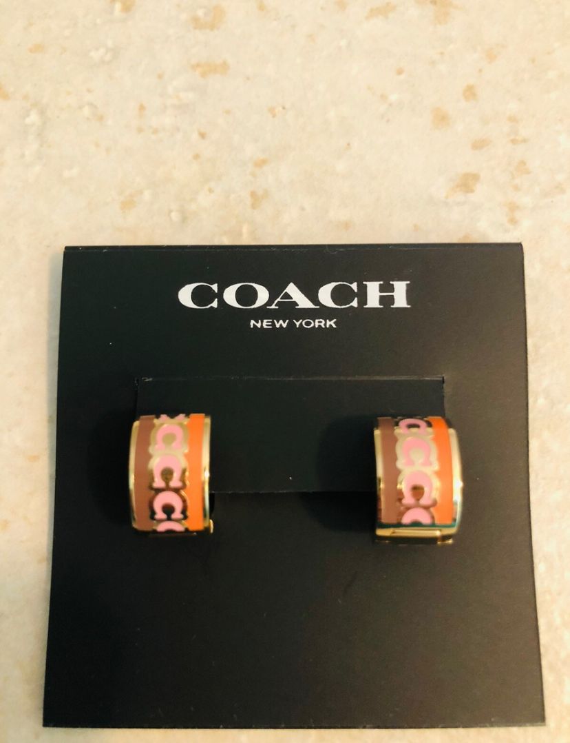 coach signature enamel huggie earrings featuring an animal print pattern and gold tone finish.