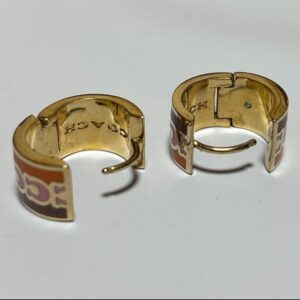 coach signature enamel huggie earrings featuring an animal print pattern and gold tone finish.